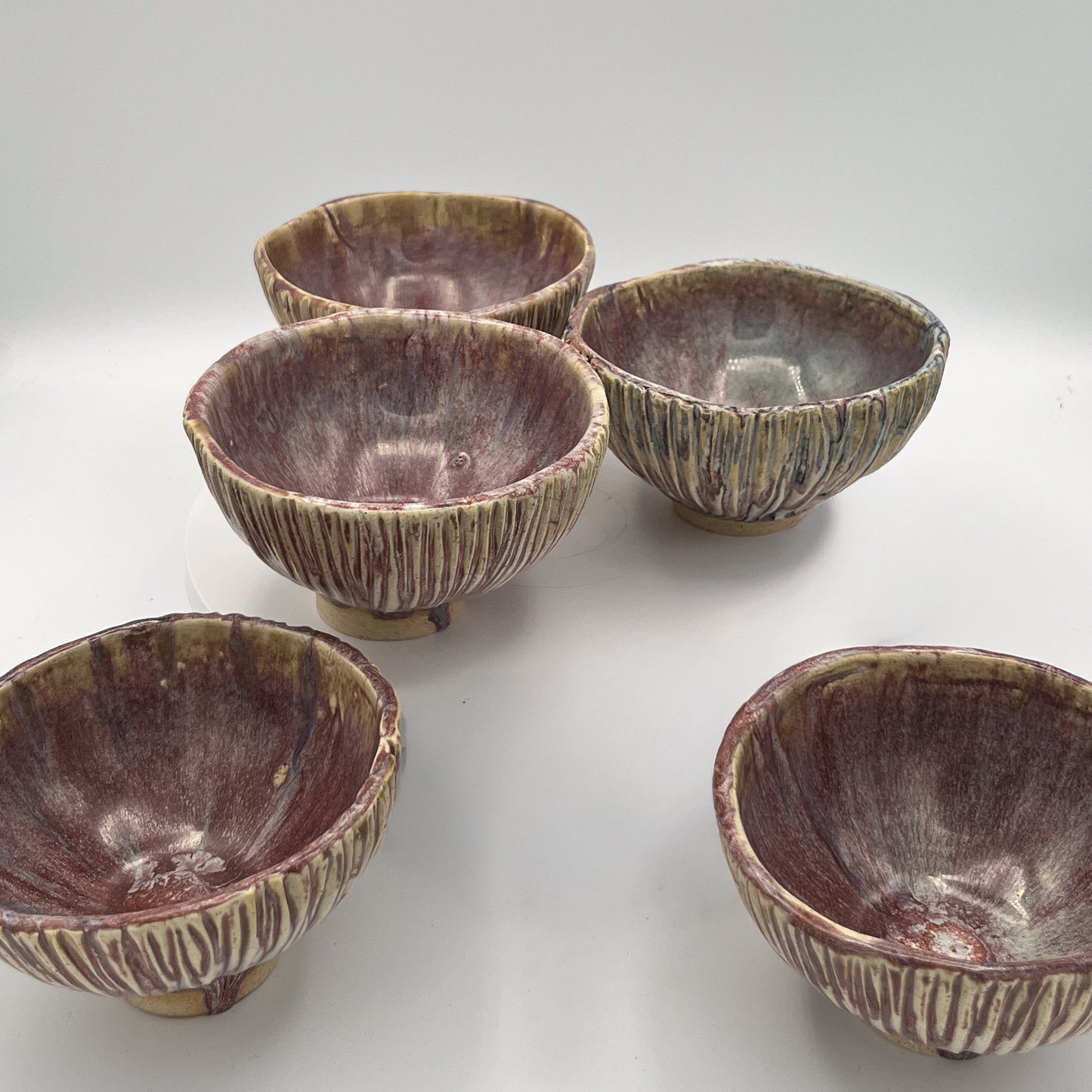 Set of five brown ceramic bowls on a white background
