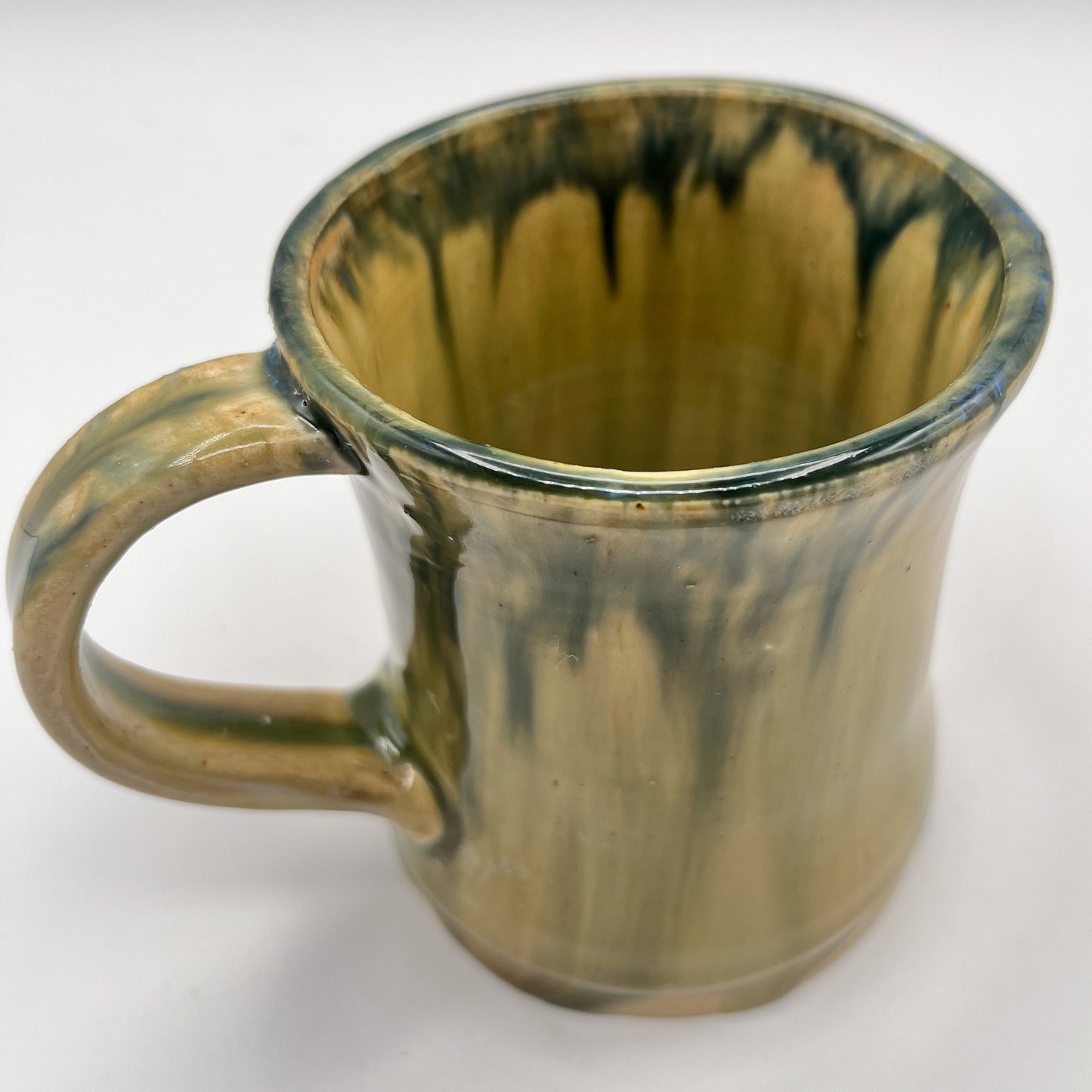 Handmade ceramic mug with moss green glaze and comfortable handle