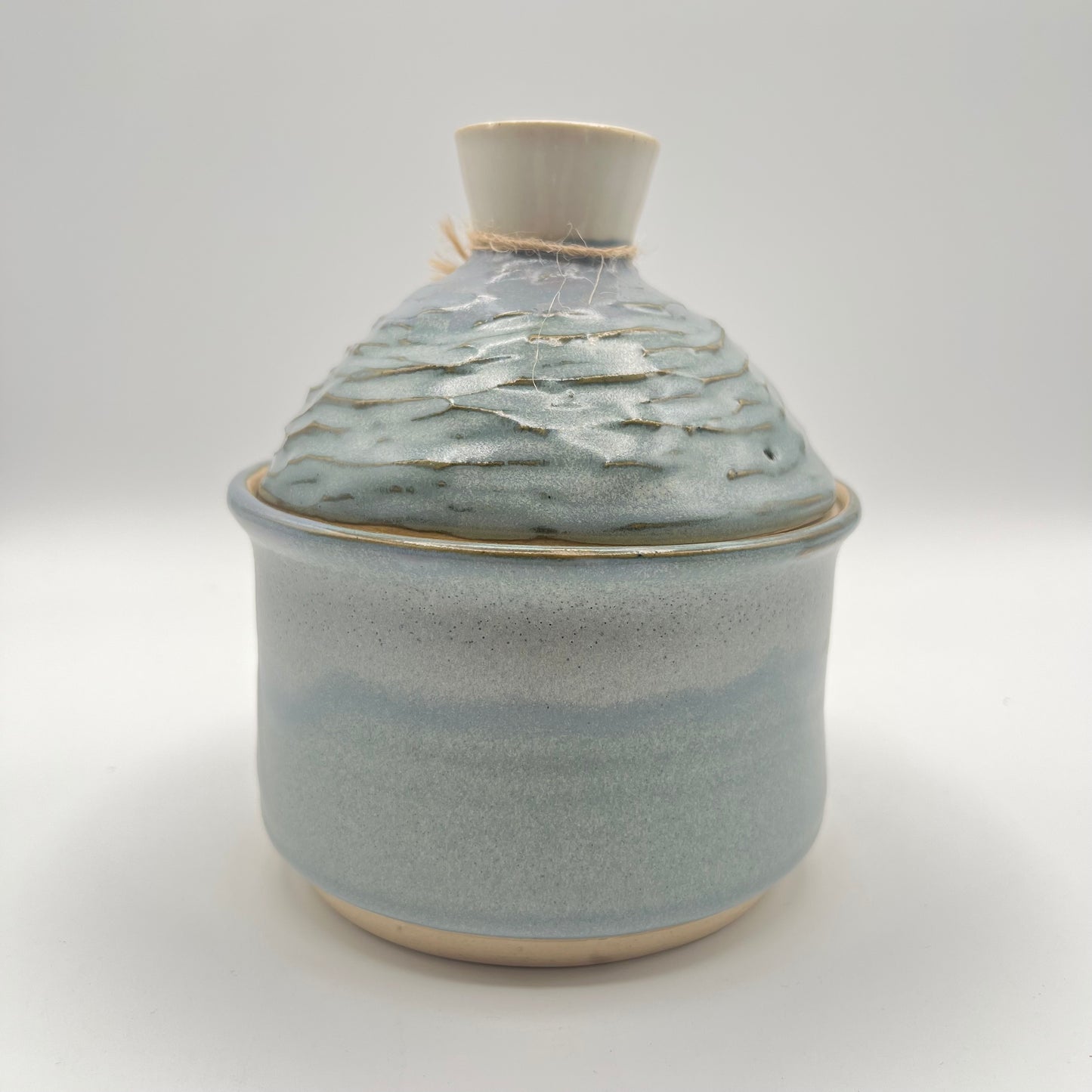 Handmade ceramic sugar bowl with blue and white glaze and textured lid
