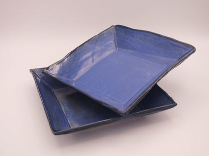 Two blue ceramic dishes on a white background