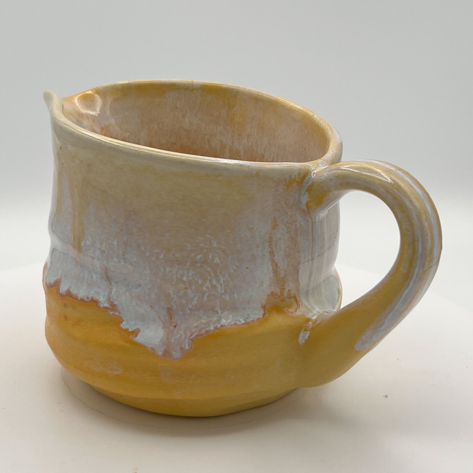 Yellow ceramic mug with a textured surface on a white background