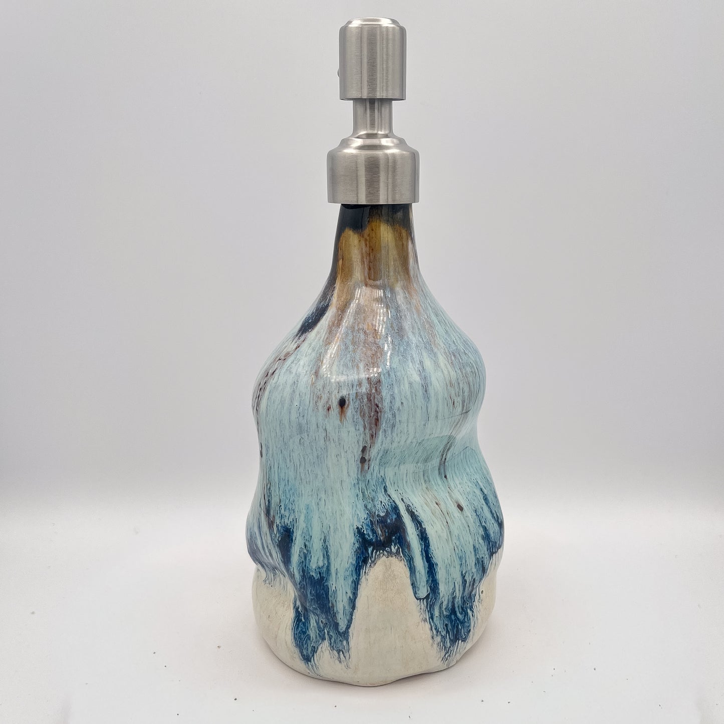 Handmade ceramic soap dispenser with blue and white flowing glaze and stainless steel pump