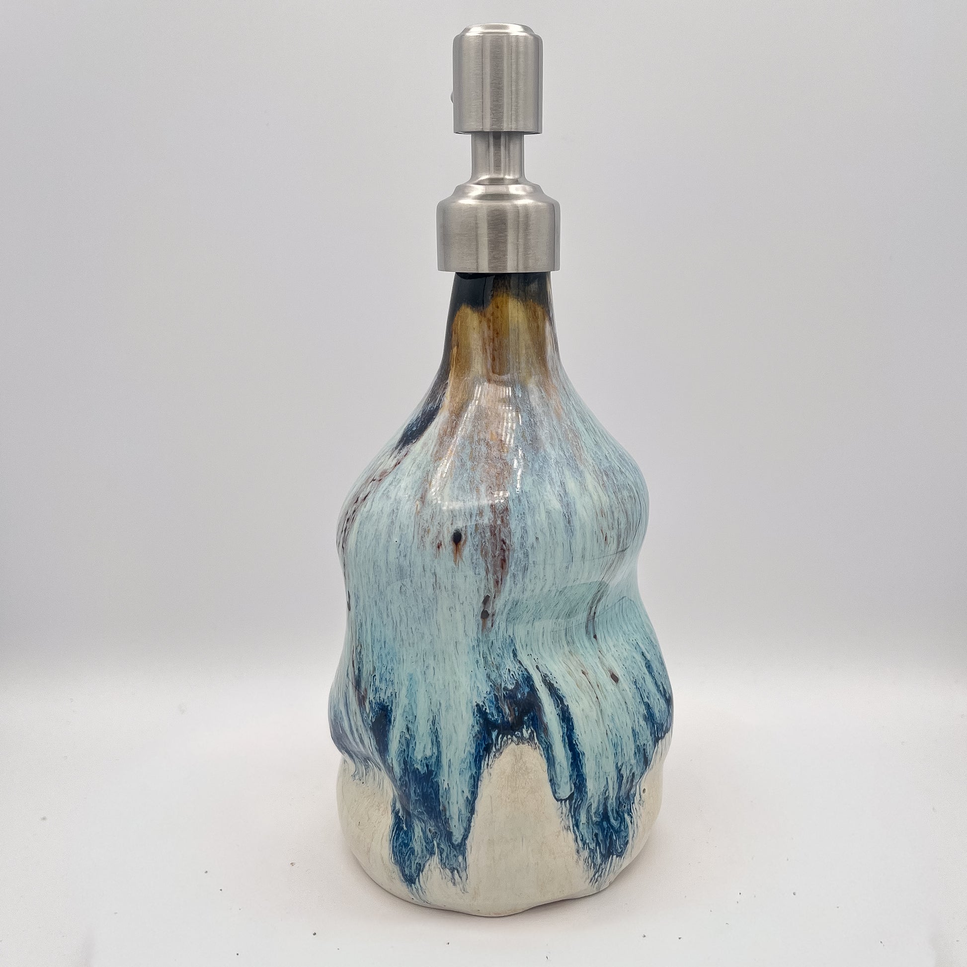 Handmade ceramic soap dispenser with blue and white flowing glaze and stainless steel pump