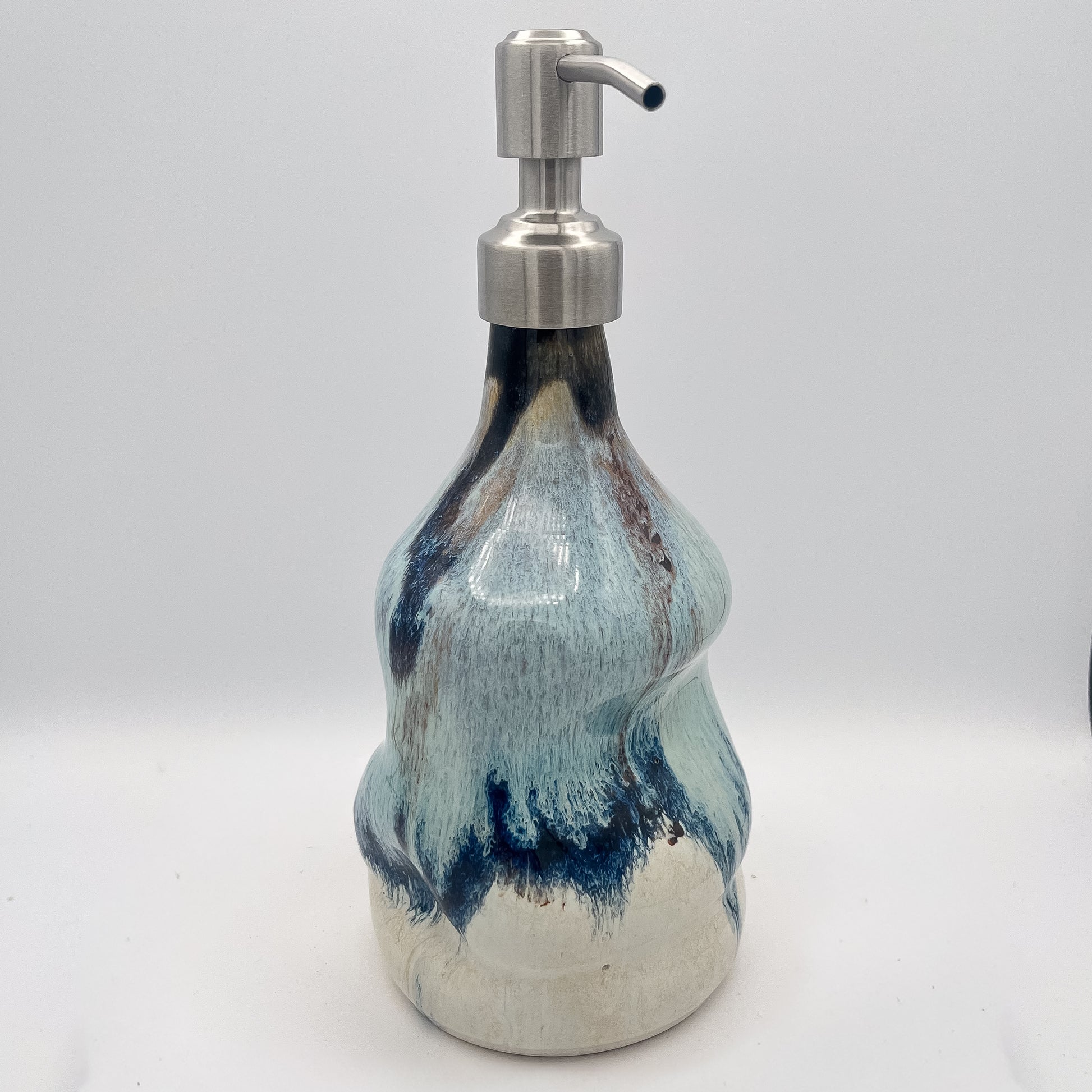 Handmade ceramic soap dispenser with blue and white flowing glaze and stainless steel pump