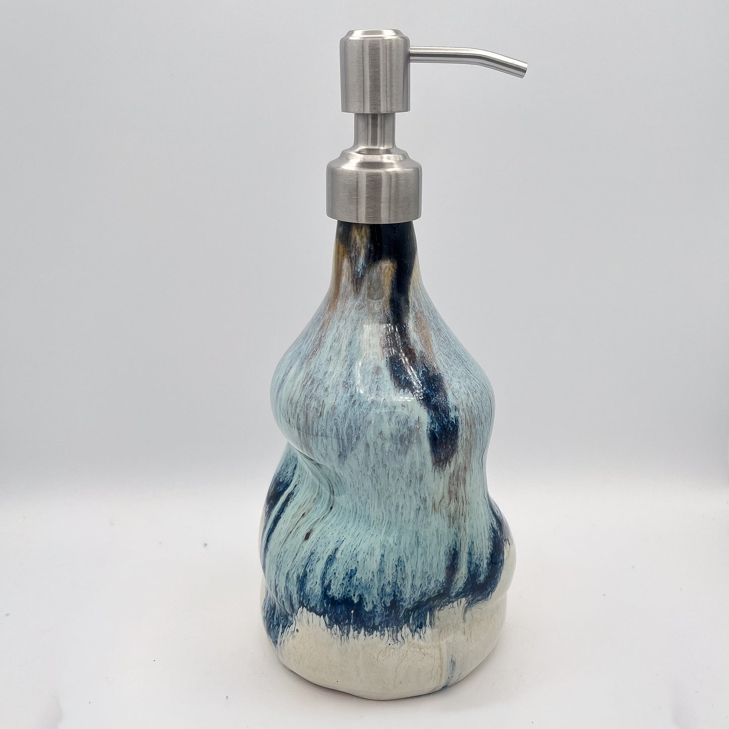 Handmade ceramic soap dispenser with blue and white flowing glaze and stainless steel pump