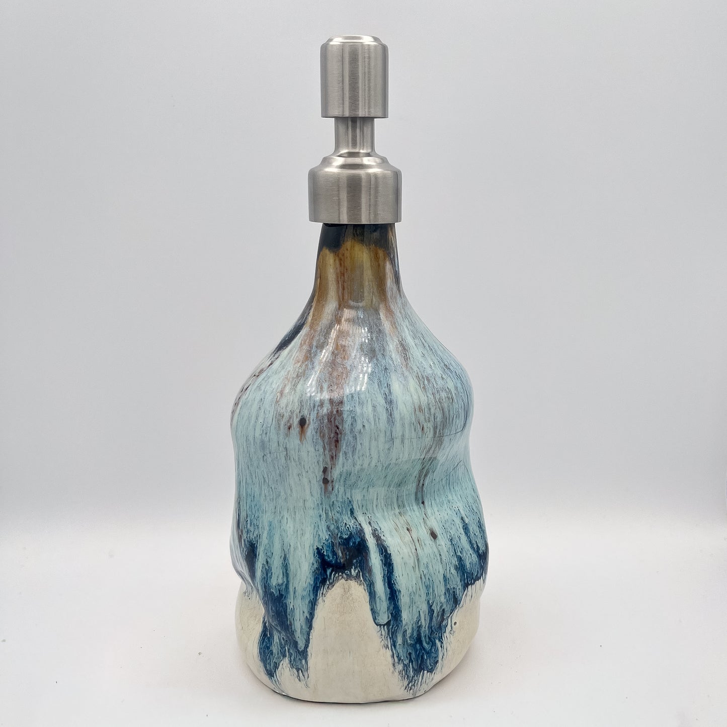 Handmade ceramic soap dispenser with blue and white flowing glaze and stainless steel pump