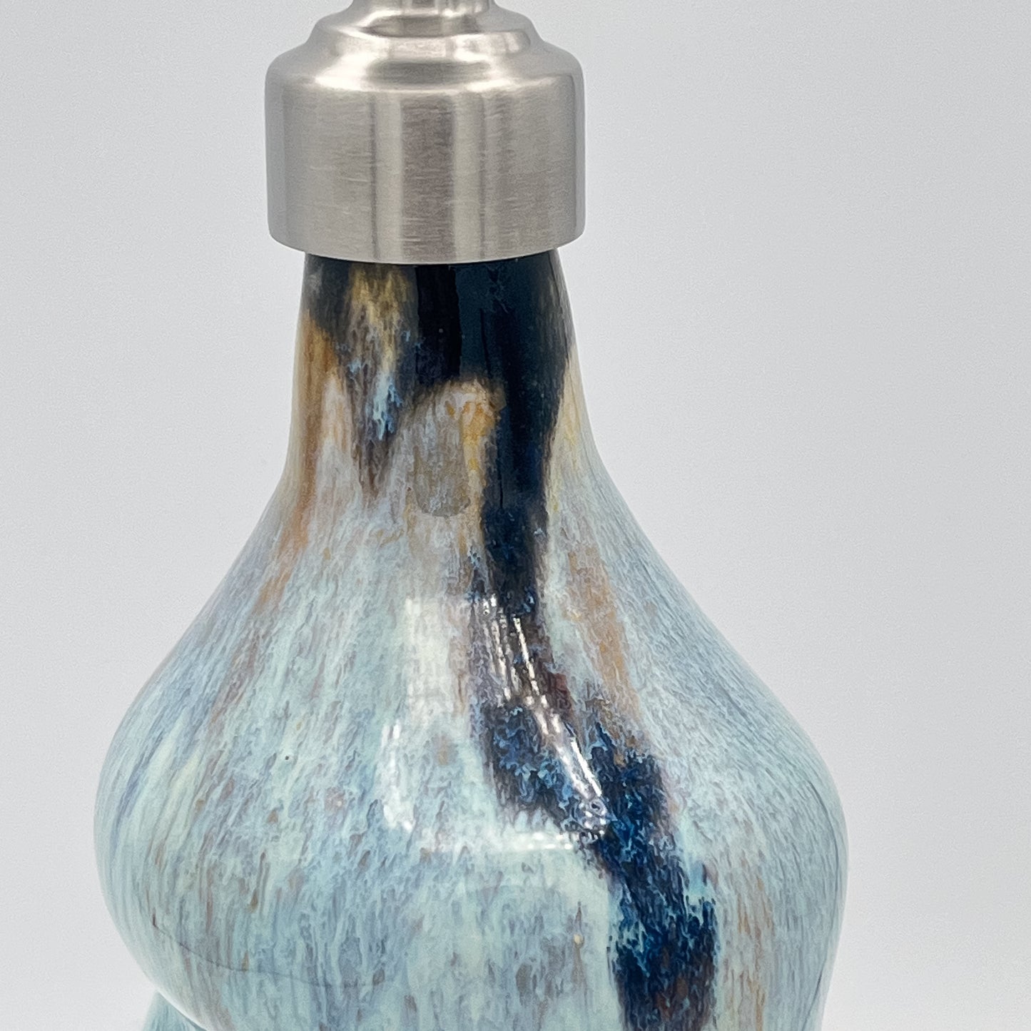 Handmade ceramic soap dispenser with blue and white flowing glaze and stainless steel pump