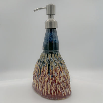 Ceramic soap dispenser with a textured design on a white background