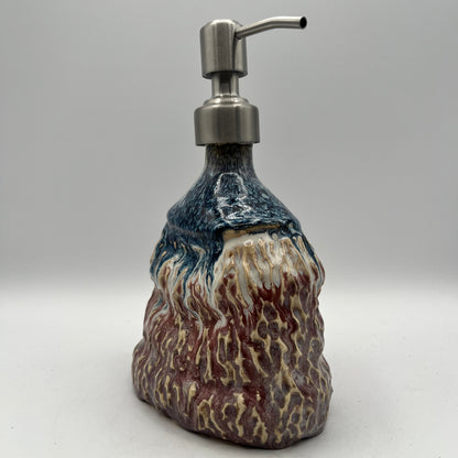 Decorative soap dispenser with a textured design on a white background