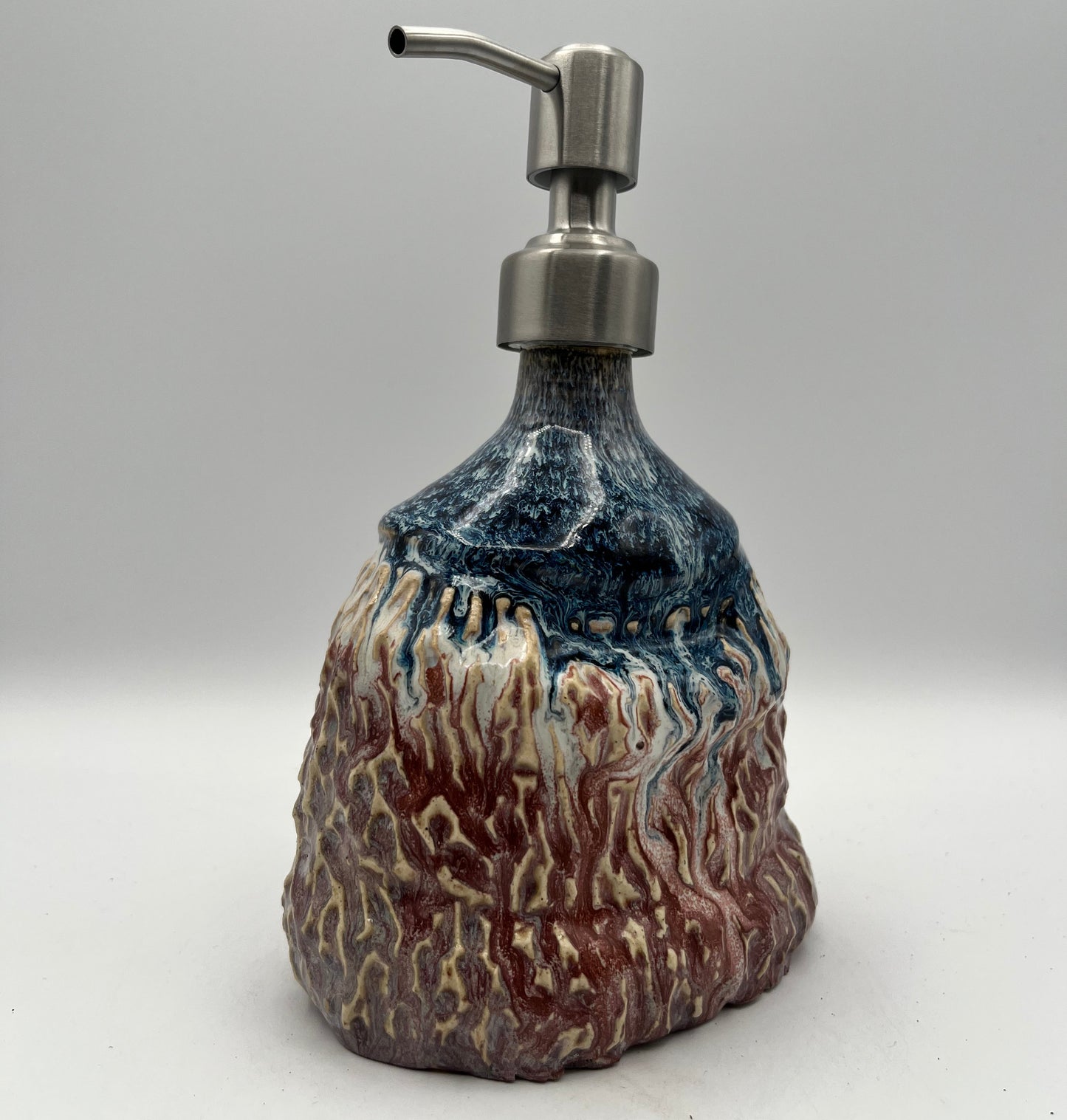 Soap dispenser with a natural stone design on a white background