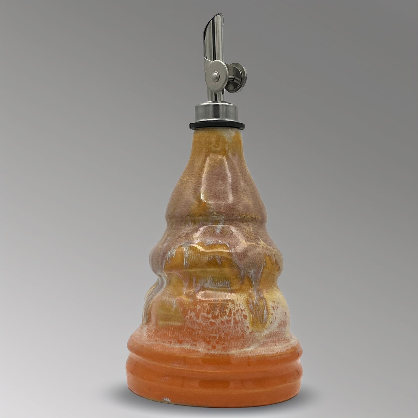 Ceramic oil decanter with a metal cap on a gray background