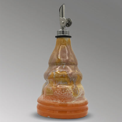 Ceramic oil decanter with a metal cap on a gray background
