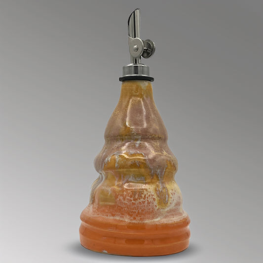 Ceramic oil decanter with a metal cap on a gray background