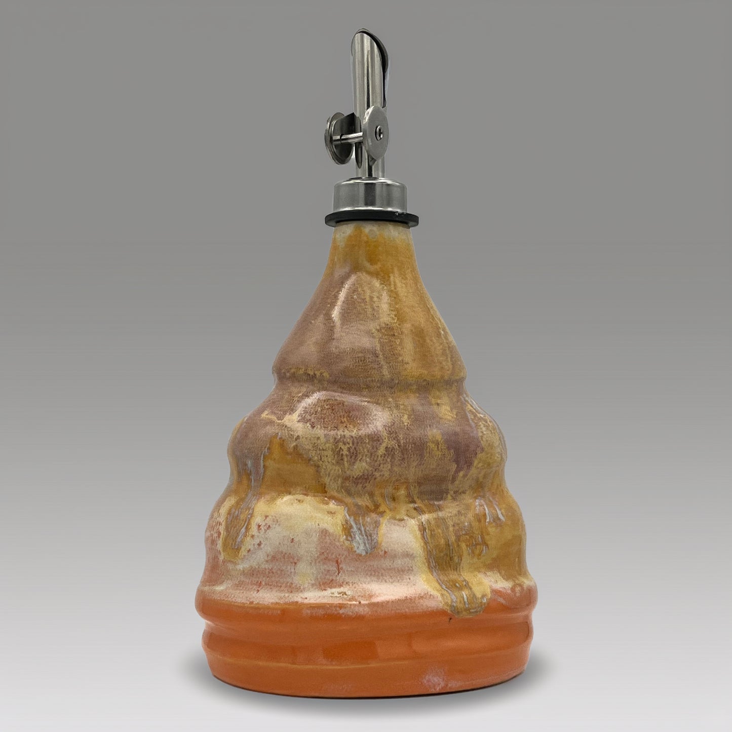 Ceramic oil decanter with a metal cap on a gray background