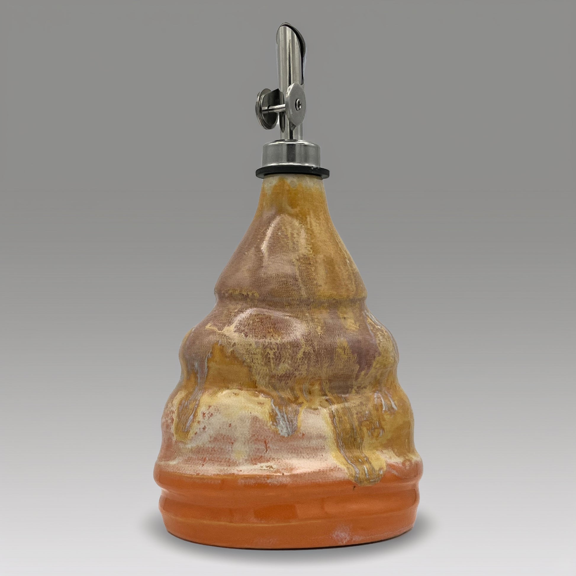 Ceramic oil decanter with a metal cap on a gray background