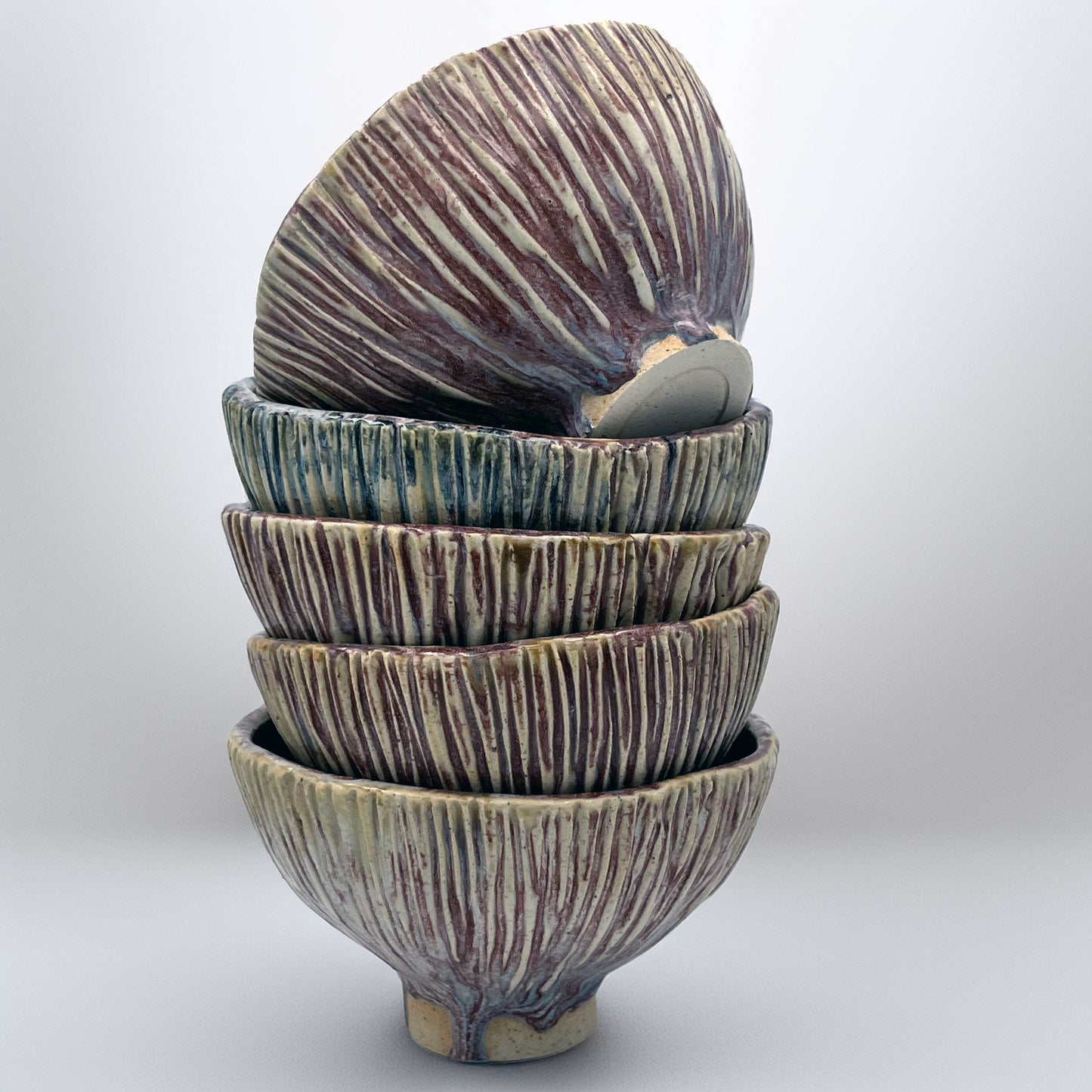 Stack of ceramic bowls with textured surface on a white background