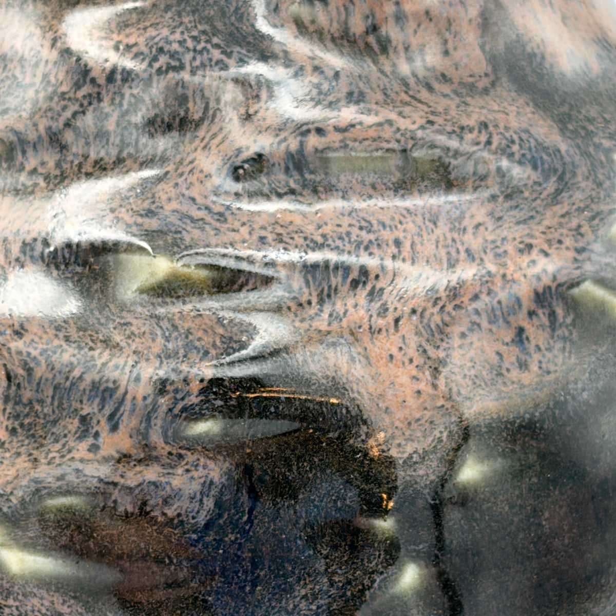 Close-up of a textured metallic surface with swirling patterns of copper, bronze, black, and silver.