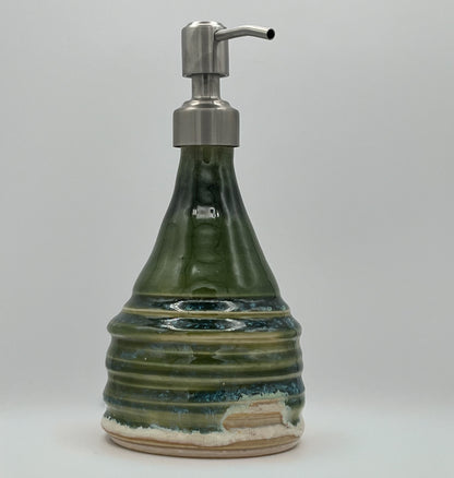 Green ceramic soap dispenser with a metallic pump on a white background
