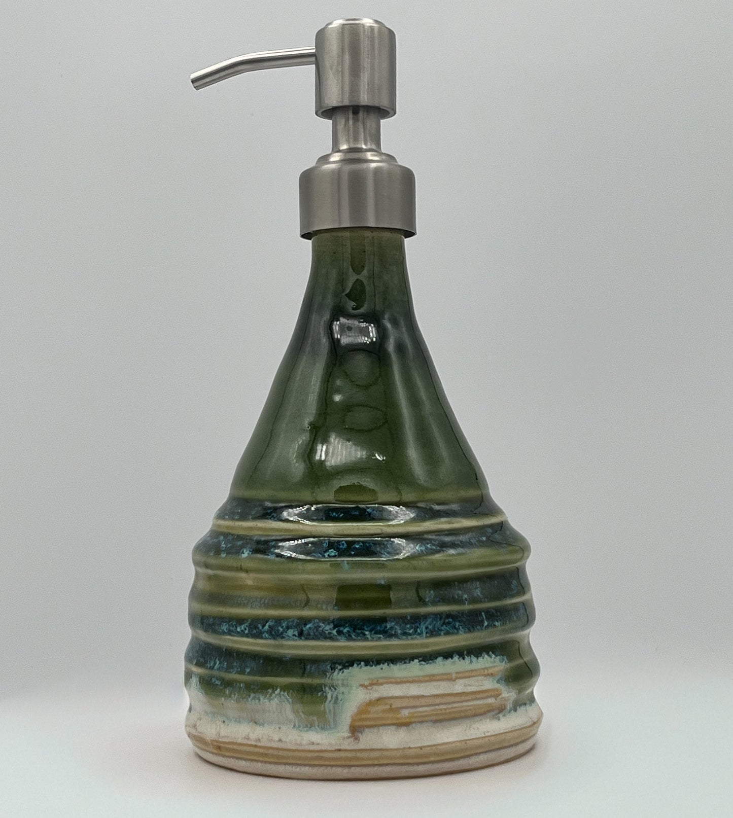 Green ceramic soap dispenser with metallic pump on a light gray background