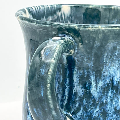 Close-up of a blue ceramic mug with a handle on a white background
