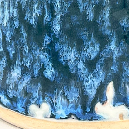 Close-up of a blue and black marbled surface with a wooden base.