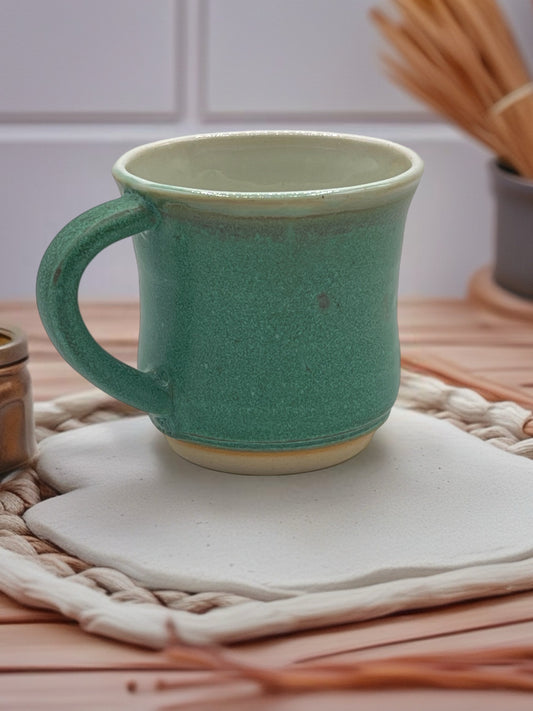 Green mug on a woven mat with a blurred background