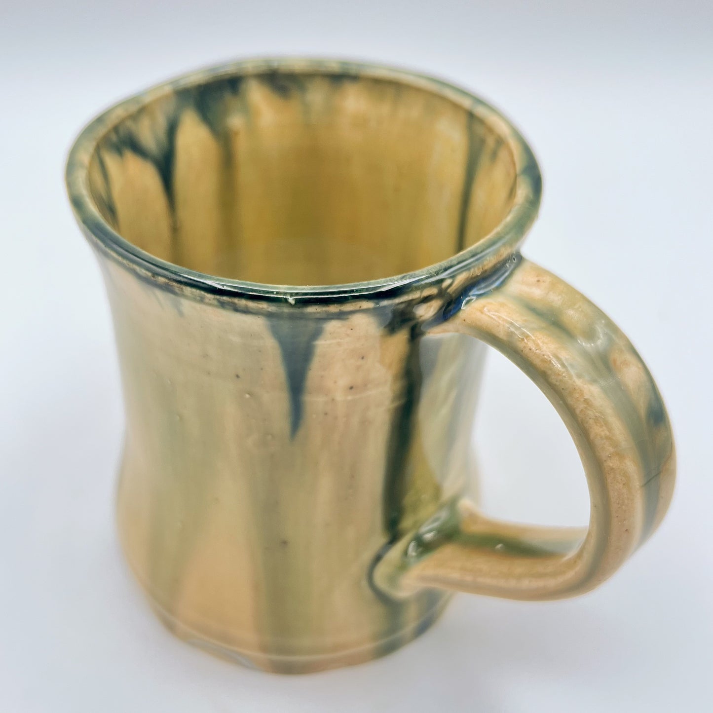 Handmade ceramic mug with moss green glaze and comfortable handle