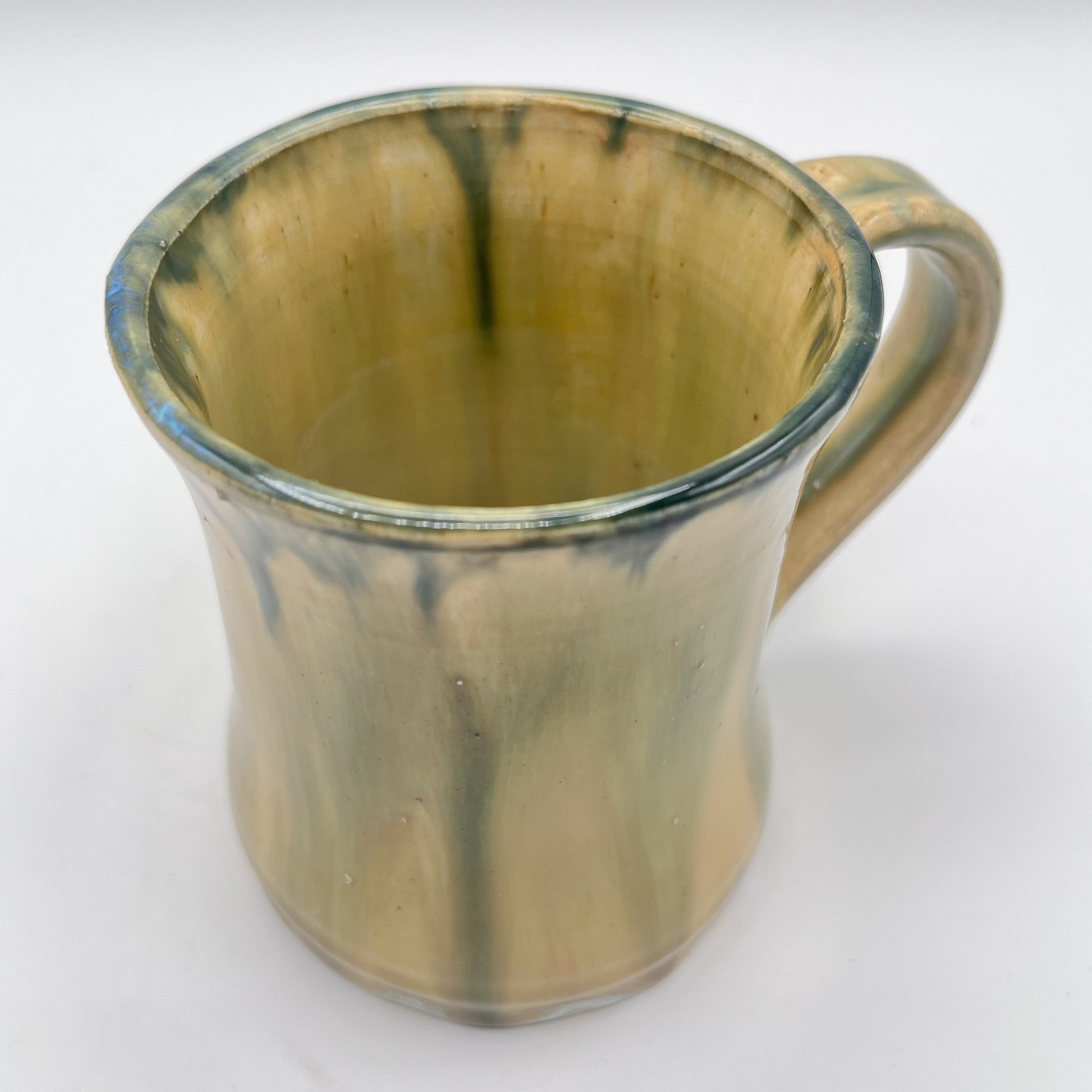 Handmade ceramic mug with moss green glaze and comfortable handle