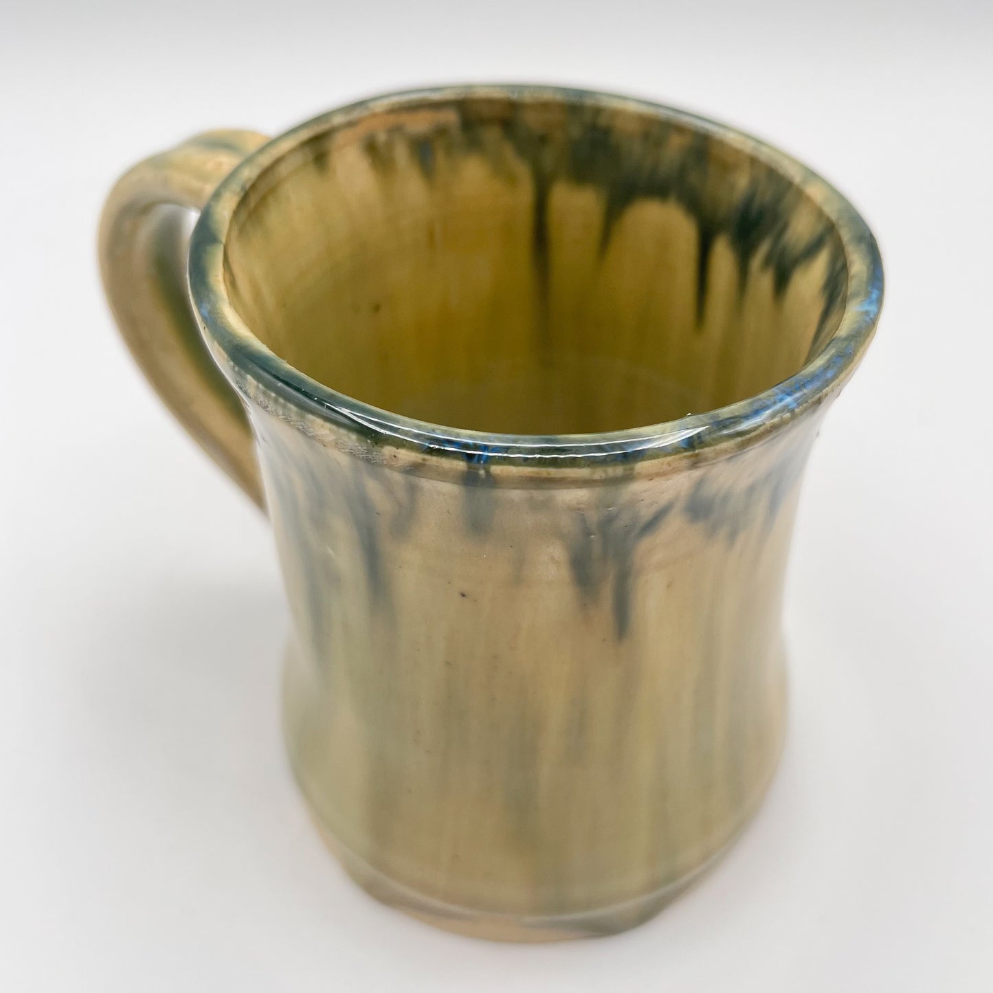 Handmade ceramic mug with moss green glaze and comfortable handle