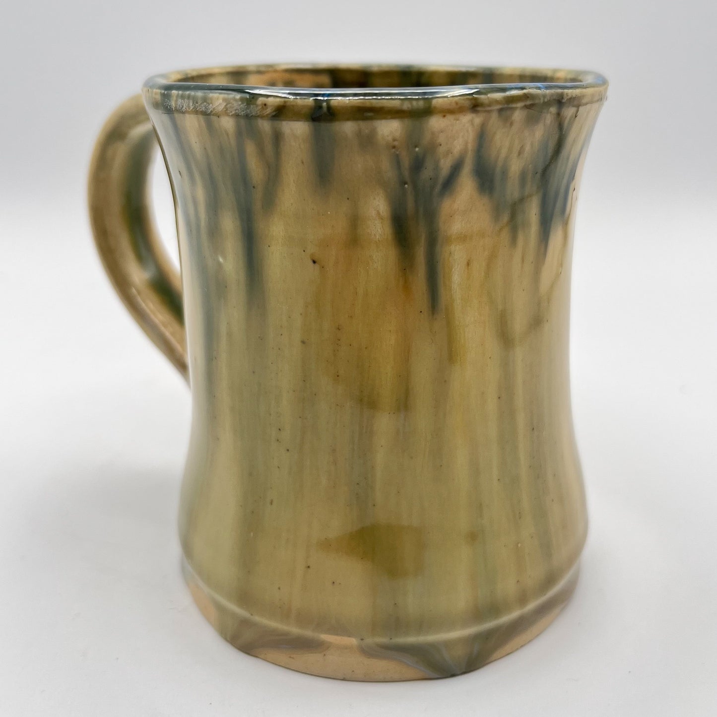 Handmade ceramic mug with moss green glaze and comfortable handle
