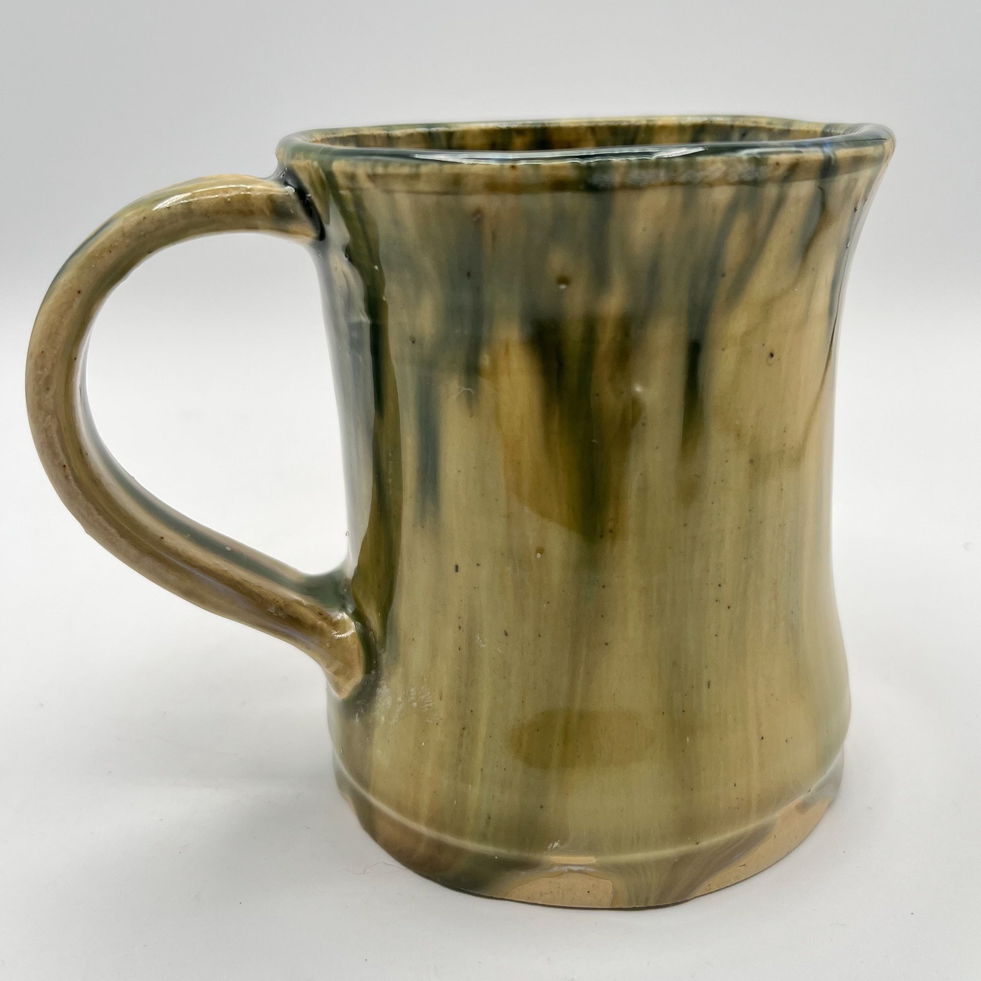 Handmade ceramic mug with moss green glaze and comfortable handle