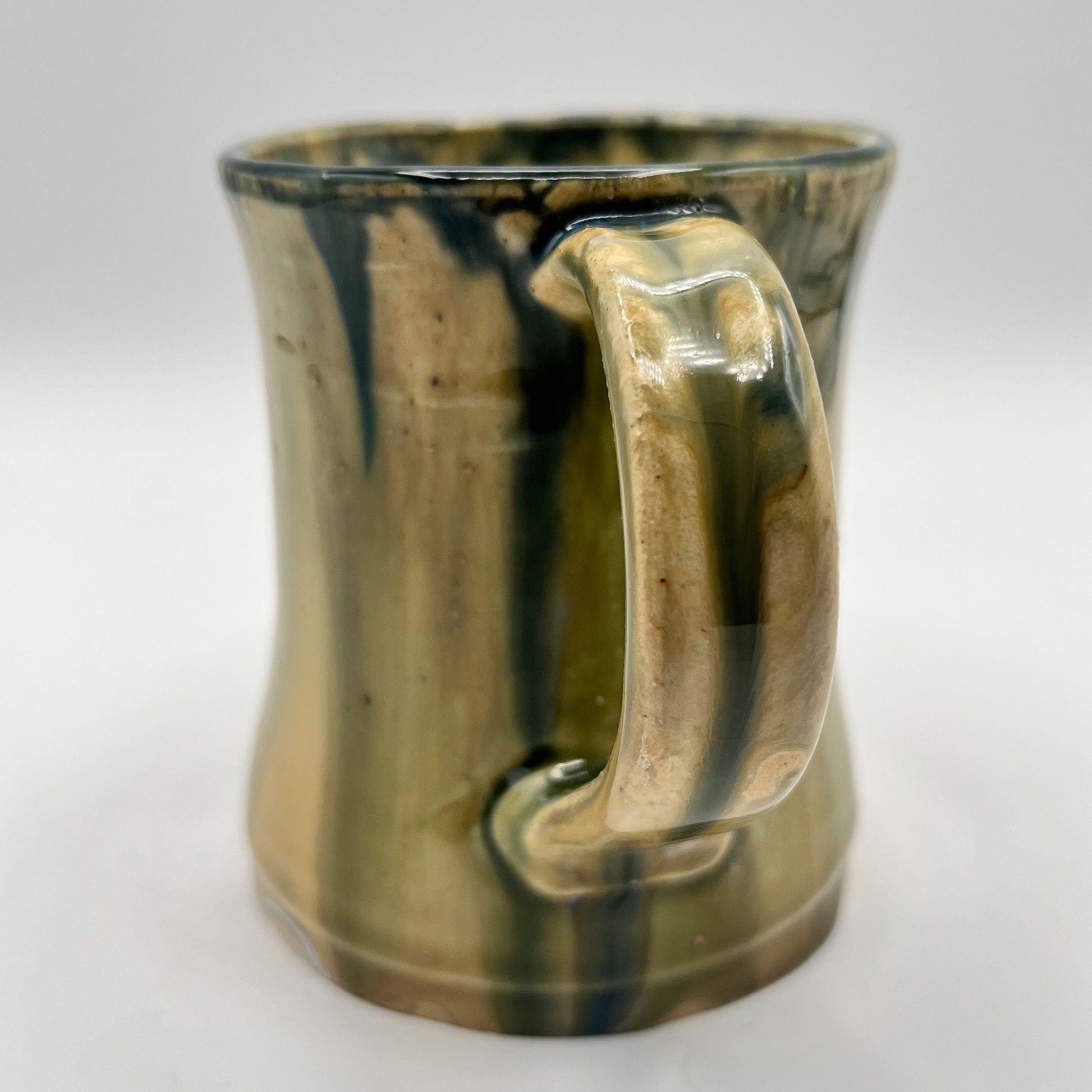 Handmade ceramic mug with moss green glaze and comfortable handle