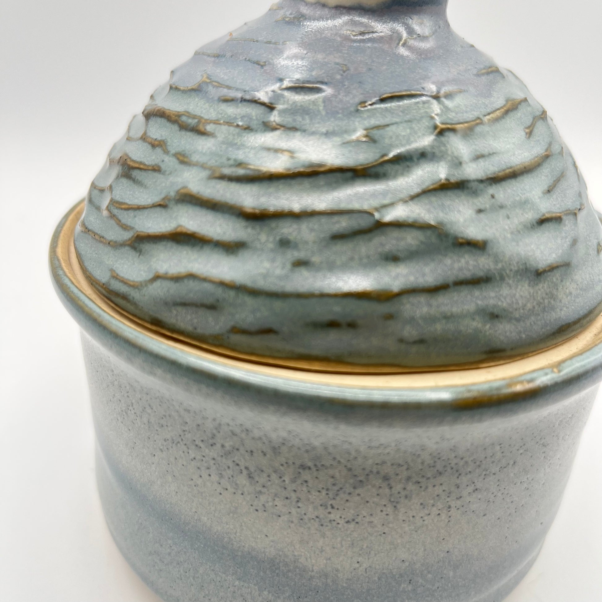 Handmade ceramic sugar bowl with blue and white glaze and textured lid