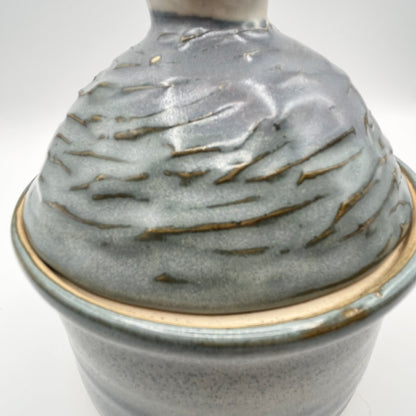 Handmade ceramic sugar bowl with blue and white glaze and textured lid