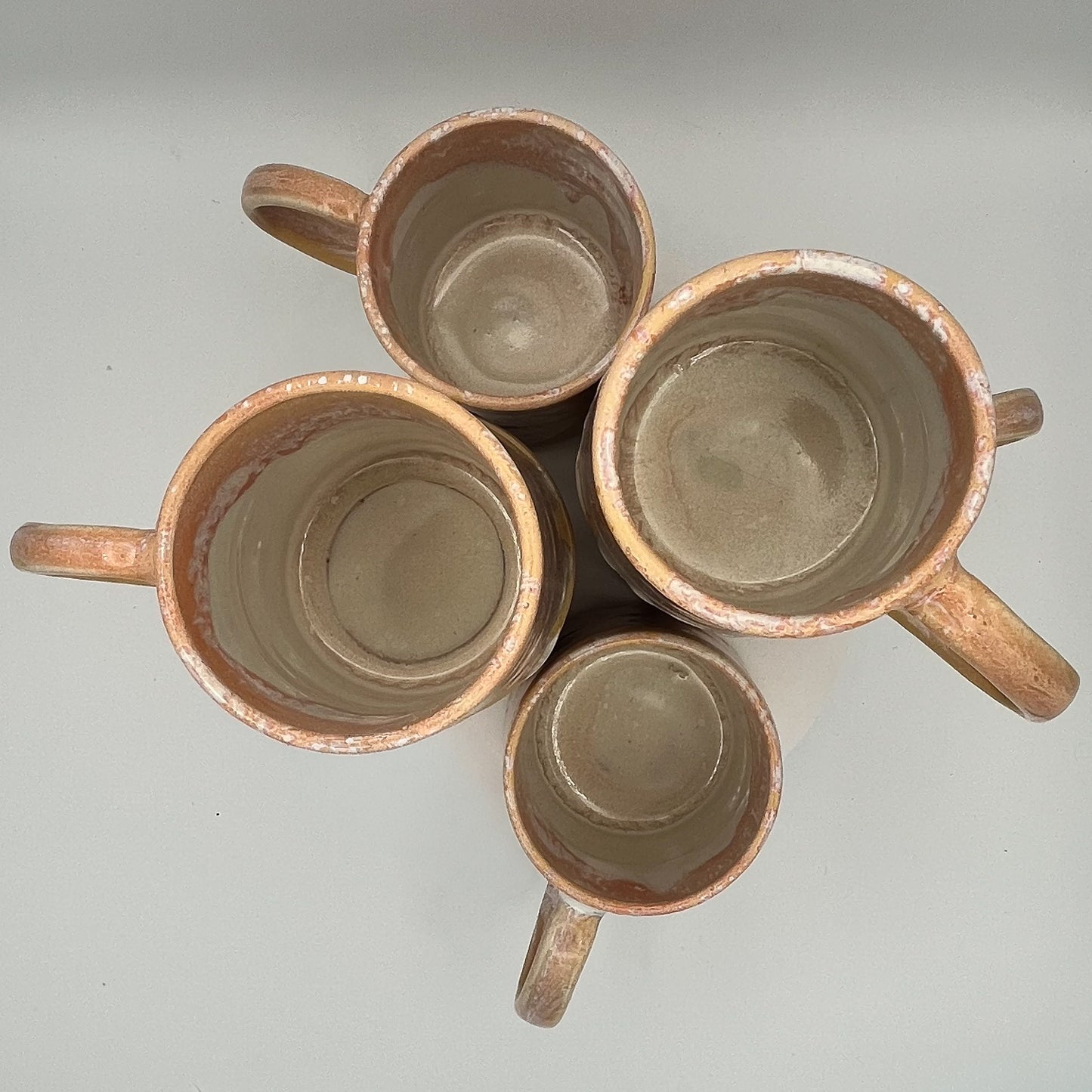 Handmade ceramic mug with peach and cream glaze and comfortable handle