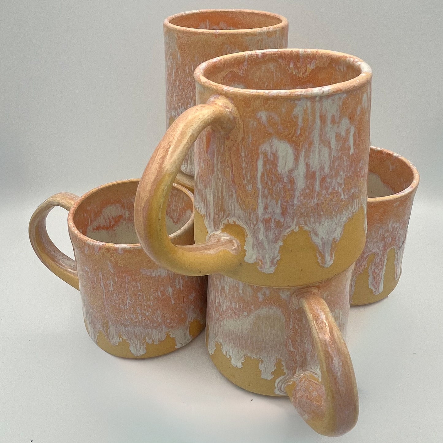 Handmade ceramic mug with peach and cream glaze and comfortable handle
