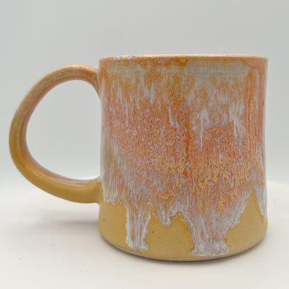 Handmade ceramic mug with peach and cream glaze and comfortable handle