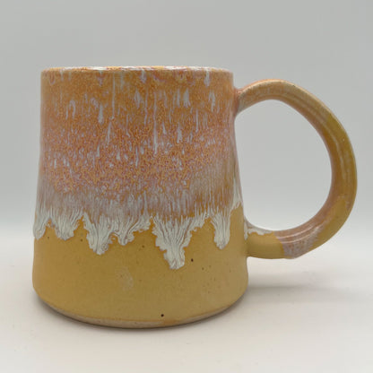 Handmade ceramic mug with peach and cream glaze and comfortable handle