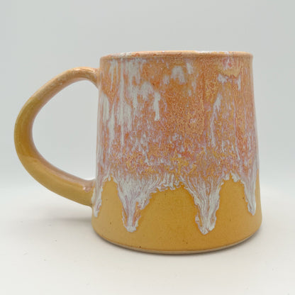 Handmade ceramic mug with peach and cream glaze and comfortable handle