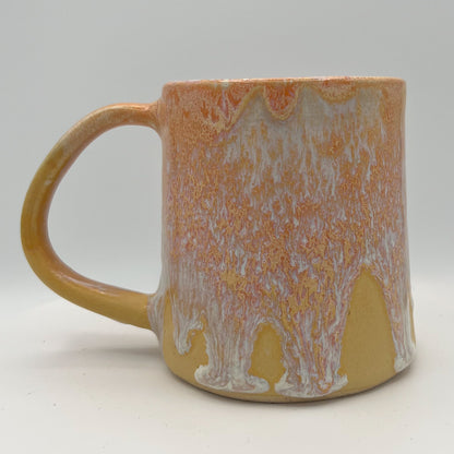 Handmade ceramic mug with peach and cream glaze and comfortable handle