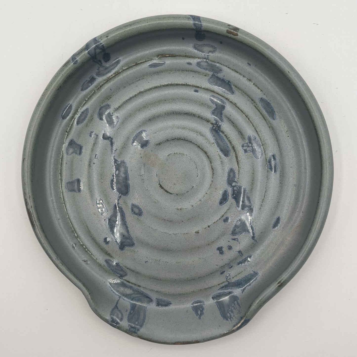 Ceramic spoonrest with textured surface on a white background