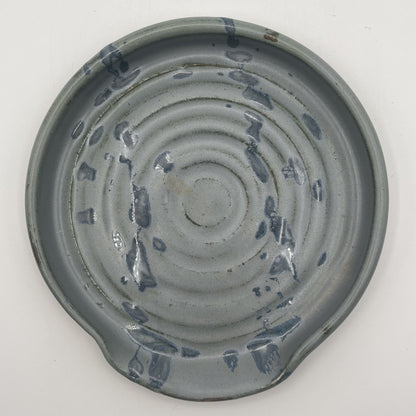 Ceramic spoonrest with textured surface on a white background